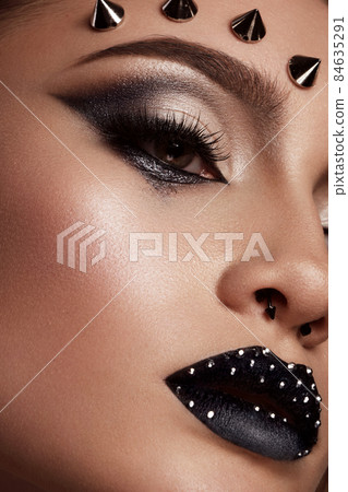 Portrait of a beautiful woman in a rock style image with creative makeup and hairstyle. Portrait of a beautiful woman in a rock style image with creative makeup and hairstyle. 84635291