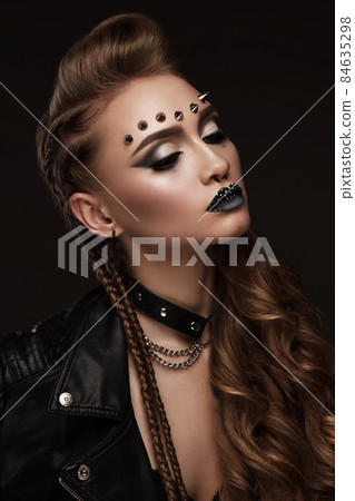 Portrait of a beautiful woman in a rock style image with creative makeup and hairstyle. Portrait of a beautiful woman in a rock style image with creative makeup and hairstyle. 84635298