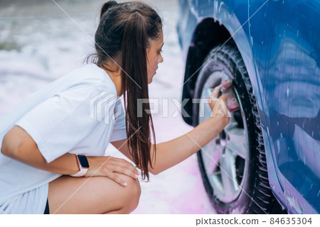 Brunette with two pigtails with a sponge washes the rim Brunette with two pigtails with a sponge washes the rim 84635304