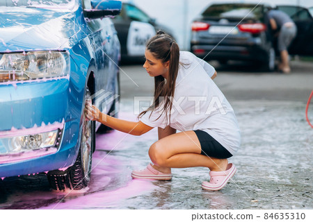 Brunette with two pigtails with a sponge washes the rim Brunette with two pigtails with a sponge washes the rim 84635310