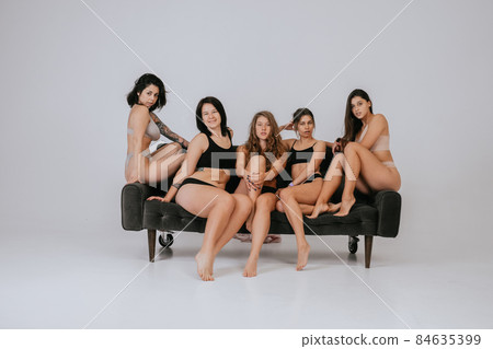 Diverse models wearing comfortable underwear posing on a large sofa 84635399