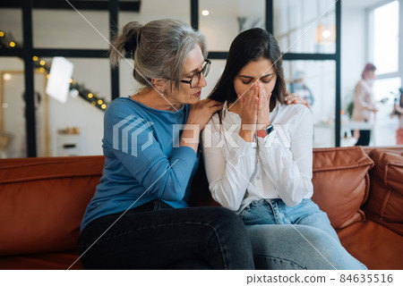 Grandmother comforting her sad granddaughter at home. Grandmother comforting her sad granddaughter at home. 84635516