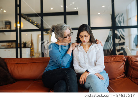 Grandmother comforting her sad granddaughter at home. Grandmother comforting her sad granddaughter at home. 84635517