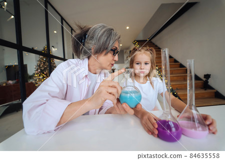 Attentive old grandma assist grandkid in funny scientific research Attentive old grandma assist grandkid in funny scientific research 84635558