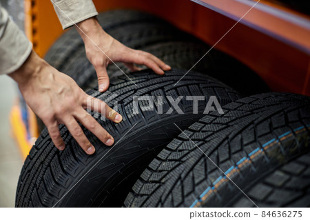 close-up of a man's hand with car tires close-up of a man's hand with car tires 84636275
