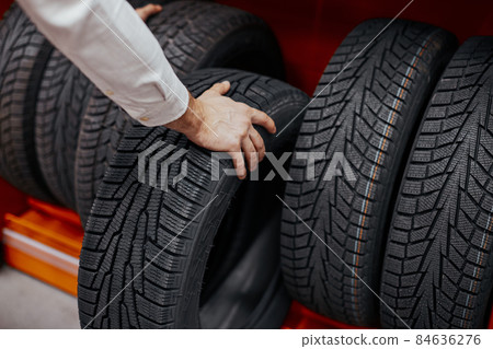 close-up of a man's hand with car tires close-up of a man's hand with car tires 84636276
