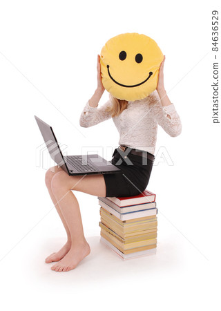Young girl is holding a smiley face pillow Young girl is holding a smiley face pillow 84636529