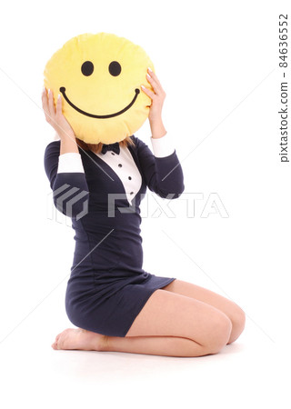 Young girl is holding a smiley face pillow Young girl is holding a smiley face pillow 84636552
