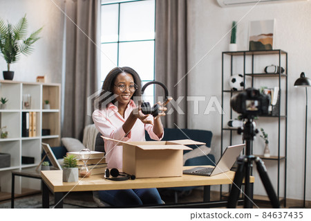 African woman recording video while unpacking box African woman recording video while unpacking box 84637435