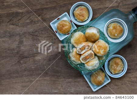A traditional asian pastry or Tao Sor in vintage green glass bowl. Chinese sweet pastry filled with mung bean paste, taro, and salted egg. 84643100