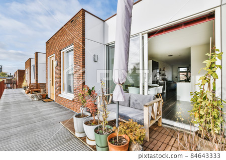 Attractive back of the apartment with open door and bench 84643333