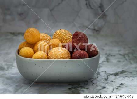 Fried Sweet Potato Balls with sesame with Deep fried purple and yellow sweet potato balls (Quail candy eggs) on marble table. Fried Sweet Potato Balls with sesame with Deep fried purple and yellow sweet potato balls (Quail candy eggs) on marble table. 84643445