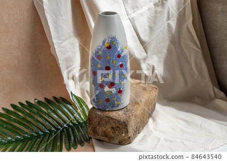 Blue and White handmade ceramic vase on white textured table cloth. 84643540