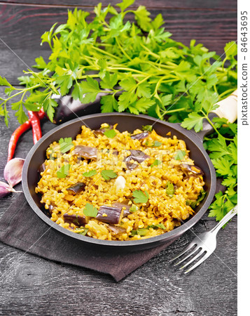 Bulgur with eggplant in pan on wooden board Bulgur with eggplant in pan on wooden board 84643695