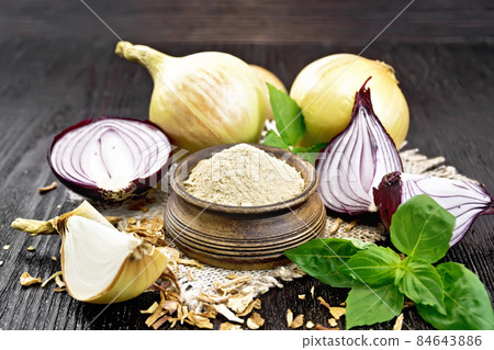 Onion powder in bowl on dark board 84643886