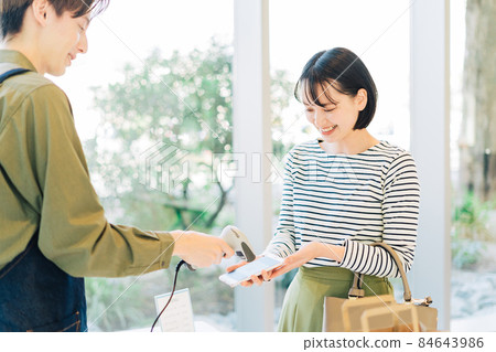 Young woman making a smartphone payment Young woman making a smartphone payment 84643986