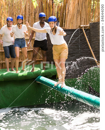 Youth in the amusement park trying to pass through an obstacle course 84644090