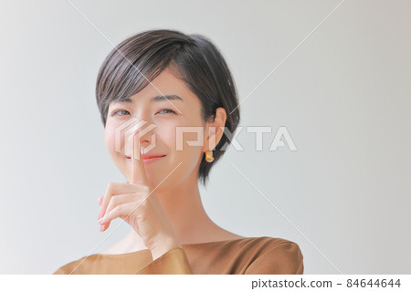 這是一個秘密_和一個微笑的女人，她把食指放在嘴上 1 84644644