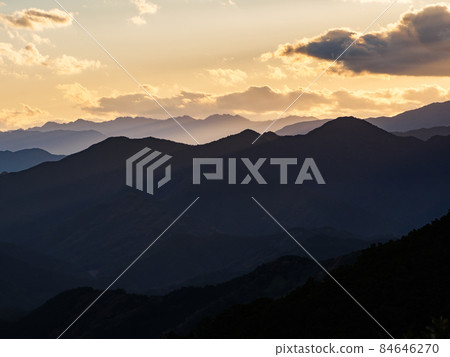 Beautiful sunset view of the Kii Mountains where the setting sun shines [From the World Heritage Kumano Kodo Tsuzurato Pass] 84646270