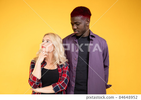 People disagreement. Argue compromise. Misunderstanding problem. Mixed race friends after conflict offended Caucasian woman confused African man isolated on yellow background. 84648952