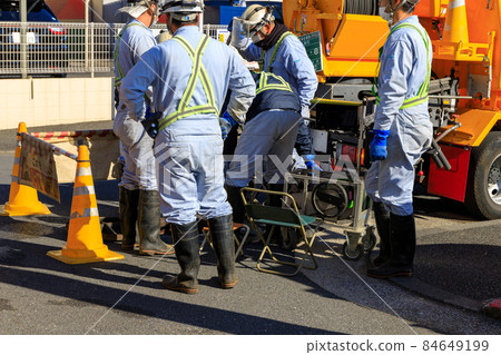 工人在路上清理沙井內部 工人在路上清理沙井內部 84649199
