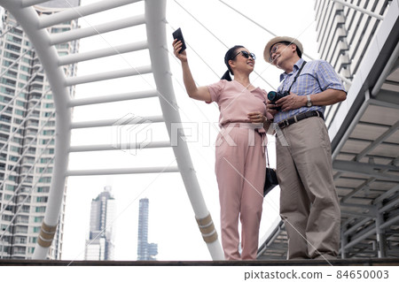 Senior Asian couple selfie by mobile outdoors. Senior Asian couple selfie by mobile outdoors. 84650003