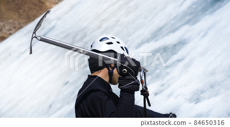 Man is climbing with ice ax on the glacier. 84650316