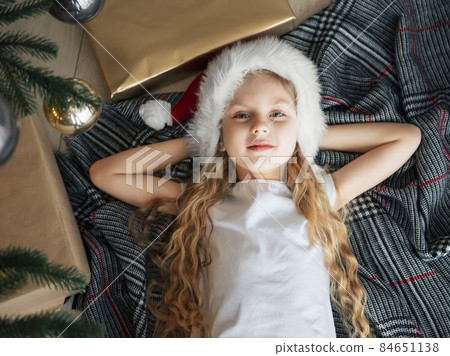 The little girl lies under the tree and dreams. 84651138