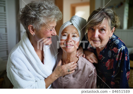 Happy senior women friends in bathrobes looking at camera indoors at home, selfcare concept. Happy senior women friends in bathrobes looking at camera indoors at home, selfcare concept. 84651589