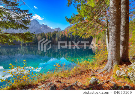 Fairytale view of Fusine lake with Mangart peak on background Fairytale view of Fusine lake with Mangart peak on background 84653169