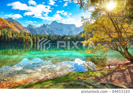 Fairytale view of Fusine lake with Mangart peak on background Fairytale view of Fusine lake with Mangart peak on background 84653183