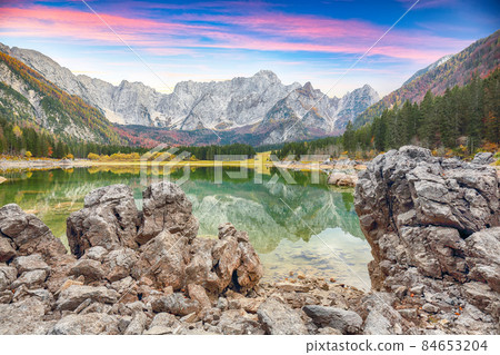 Fairytale view of Fusine lake with Mangart peak on background. Fairytale view of Fusine lake with Mangart peak on background. 84653204