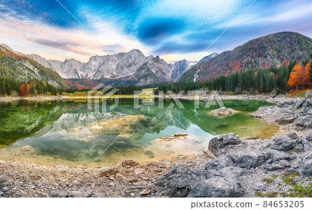 Breathtaking view of sunset over Fusine lake with Mangart peak on background. Breathtaking view of sunset over Fusine lake with Mangart peak on background. 84653205