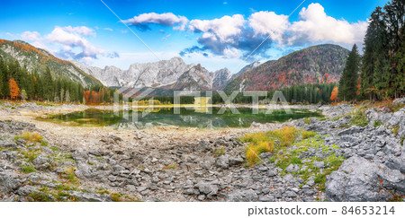 Fairytale view of Fusine lake with Mangart peak on background. Fairytale view of Fusine lake with Mangart peak on background. 84653214