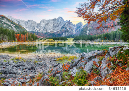 Fairytale view of Fusine lake with Mangart peak on background. Fairytale view of Fusine lake with Mangart peak on background. 84653216