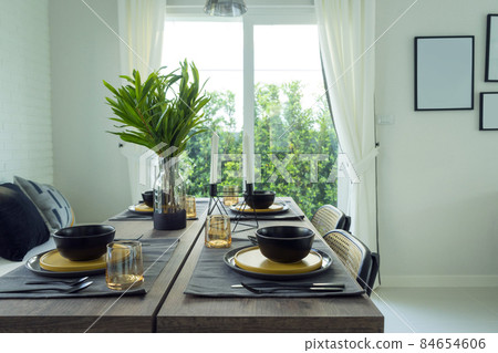 dining table with black and yellow plate setting in modern home. dining table with black and yellow plate setting in modern home. 84654606