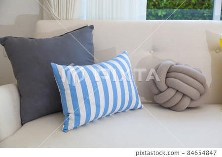 Modern design of living room with yellow,blue and orange pillow on sofa. Colorful living room interior. 84654847