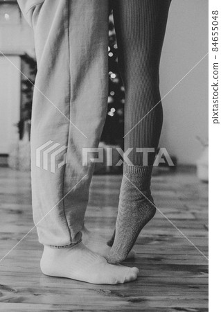 female feet stand on male close-up against the background of a christmas tree female feet stand on male close-up against the background of a christmas tree 84655048