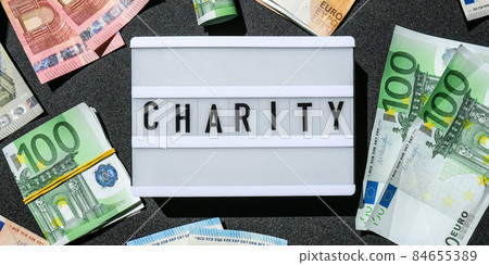 Lightbox board with word CHARITY in black letters around Euro banknotes. Money, Business, finance, investment, saving Lightbox board with word CHARITY in black letters around Euro banknotes. Money, Business, finance, investment, saving 84655389