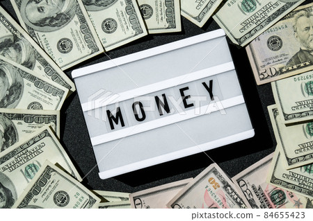 Lightbox board with the word MONEY in black letters around Us dollar banknotes. Finance background. Business, financial success and making money concept. Business budget of wealth and prosperity Lightbox board with the word MONEY in black letters around Us dollar banknotes. Finance background. Business, financial success and making money concept. Business budget of wealth and prosperity 84655423
