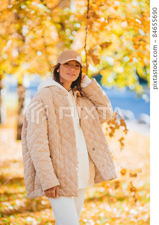 Fall concept - beautiful woman drinking coffee in autumn park under fall foliage Fall concept - beautiful woman drinking coffee in autumn park under fall foliage 84655690