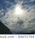 Auspicious iridescent clouds seen from between the buildings 84655768