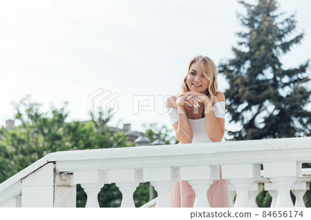 beautiful blonde woman dancing to music outside 84656174