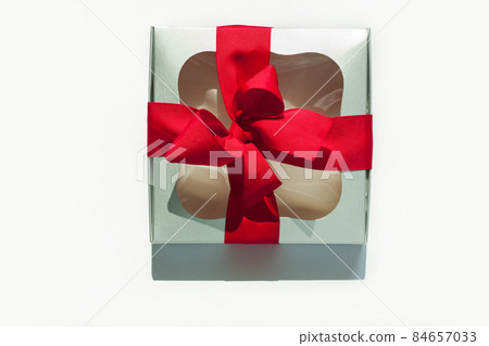Silver gift box with red ribbon bow isolated on white background. Copy space, flatlay, top view. 84657033