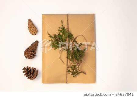 Eco gift box wrapping in kraft paper on white background isolated.Composition present decorated Christmas tree branches. Eco gift box wrapping in kraft paper on white background isolated.Composition present decorated Christmas tree branches. 84657041