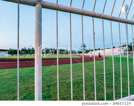 The fenced off stadium where people are exercising is jogging, walking, kicking football and so on, there's plenty of activity to do. 84657114