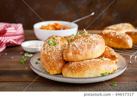 Homemade baked pies or patties stuffed with cabbage on wooden background 84657317