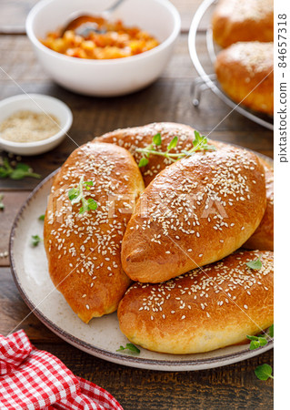 Homemade baked pies or patties stuffed with cabbage on wooden background 84657318