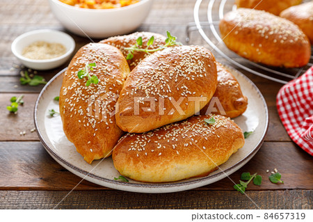 Homemade baked pies or patties stuffed with cabbage on wooden background 84657319