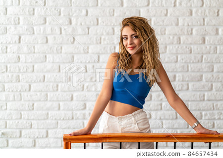 Young woman leans to the railing and looking to a point wiyh a smily face. Young woman leans to the railing and looking to a point wiyh a smily face. 84657434
